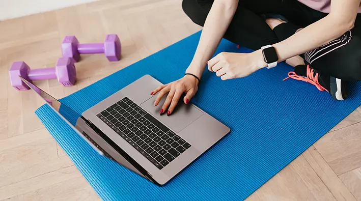 A person is sitting on the floor with their laptop.