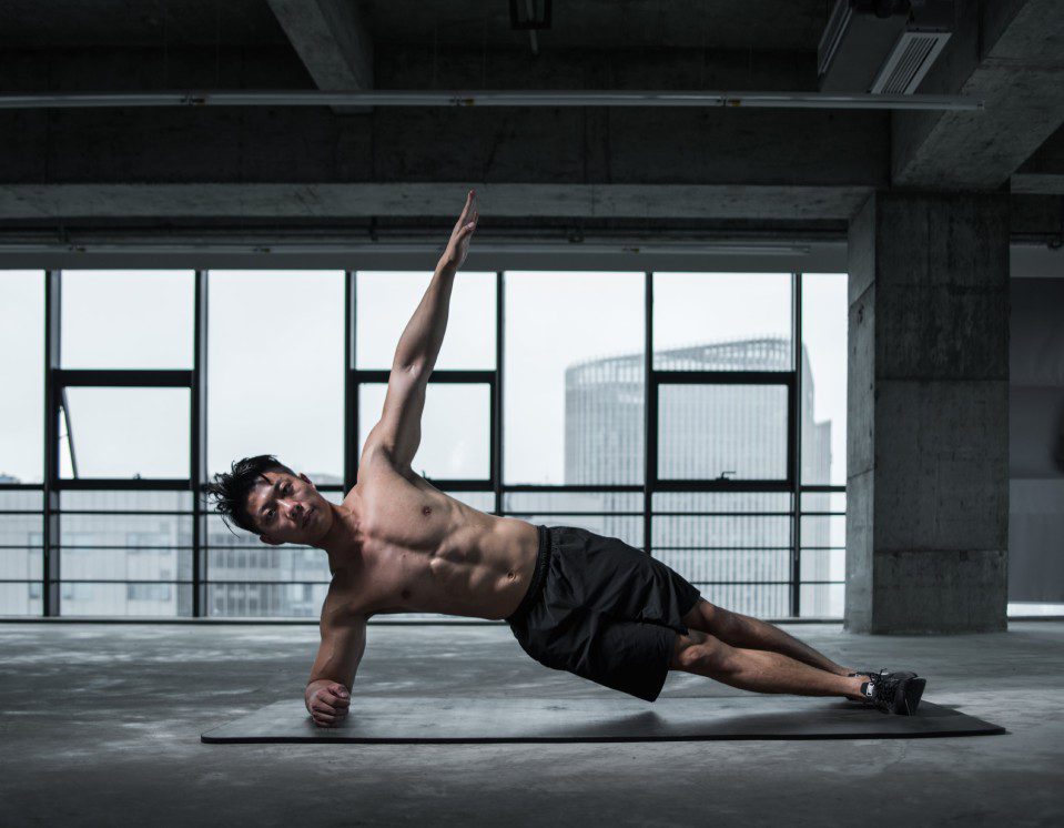 A man is doing side plank on the floor