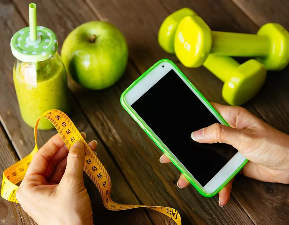 A person is holding a phone and measuring tape.