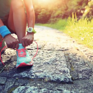 Woman ties her shoe before running.