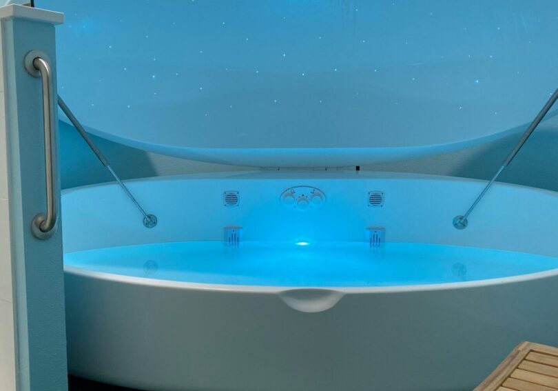 A large white tub with blue lights inside of it.